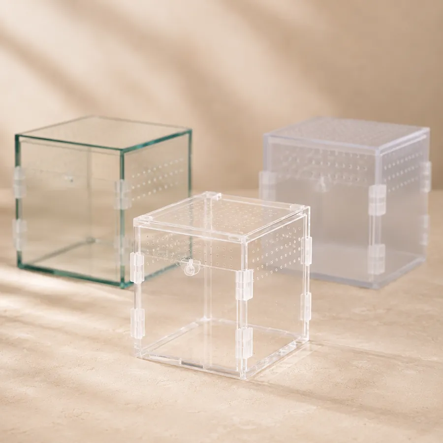 A glass cube beside two clear acrylic enclosures, showing the difference in panel clarity and bulk
